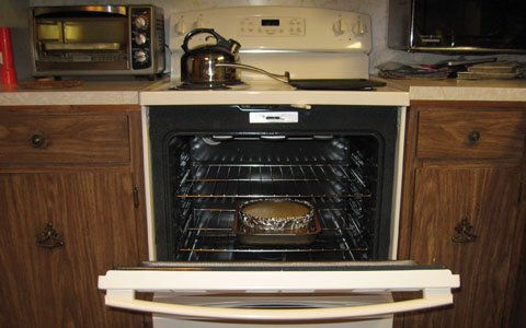 New cooking range with cheesecake in oven